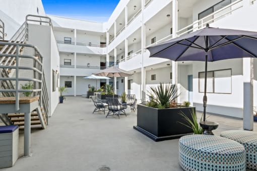 an outdoor patio with tables and chairs and umbrellas at a hotel