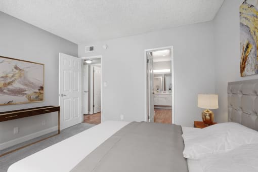 a bedroom with a large bed and a door to a bathroom