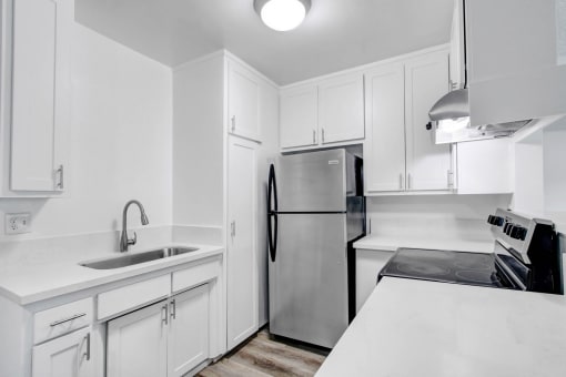 a kitchen with white cabinets and a stainless steel refrigerator