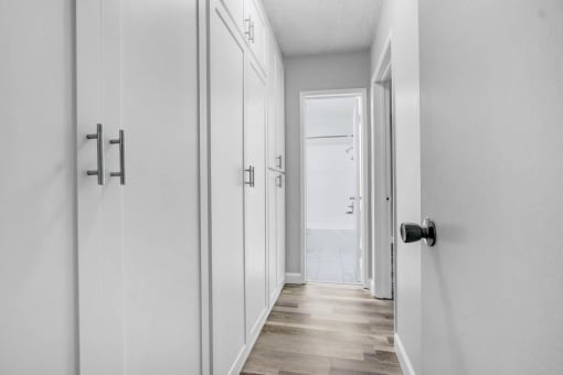 a white hallway with white closets and a door to the beach