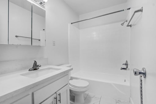 a white bathroom with a sink toilet and shower