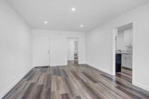 a living room with white walls and wood floors