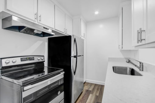 a kitchen with white cabinets and stainless steel appliances