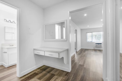 a white bathroom with a vanity and a mirror