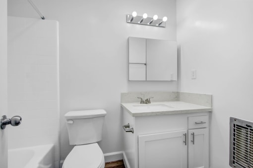 a white bathroom with a toilet and a sink