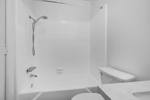 a white bathroom with a shower and a toilet