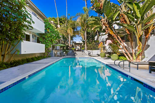 the swimming pool at the backyard of a house with a blue pool