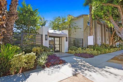 a house with a sidewalk and trees in front of it