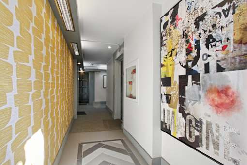a hallway with paintings on the wall and a corridor with a door