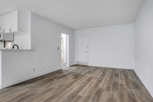 a bedroom with hardwood floors and white walls