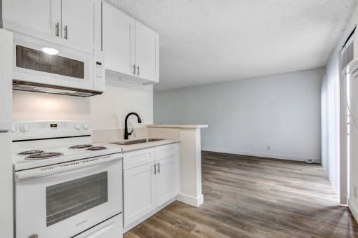 a kitchen with white cabinets and a white stove top oven