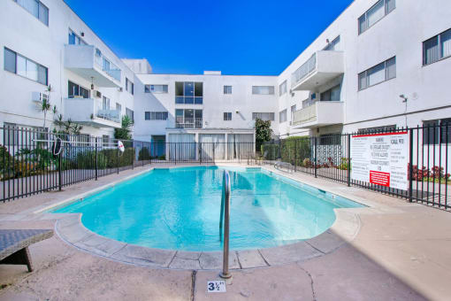 a swimming pool in front of an apartment building