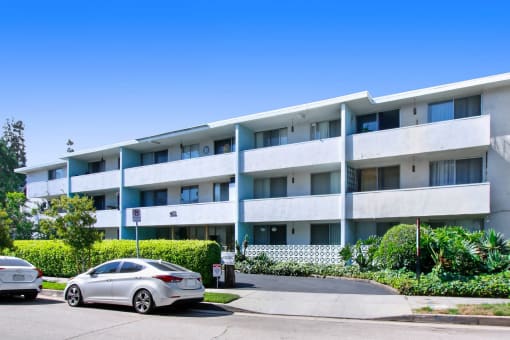 a white car parked in front of an apartment building