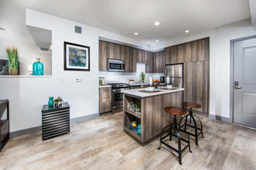 A kitchen with a bar stool and a fridge.