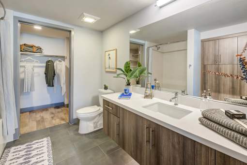 A bathroom with a toilet, sink, and mirror.