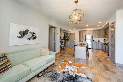 A living room with a green couch and a rug with a star design on it.