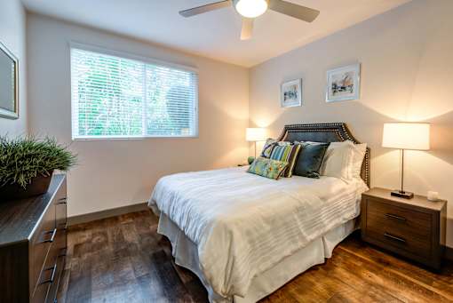 A bedroom with a bed, nightstands, and a ceiling fan.