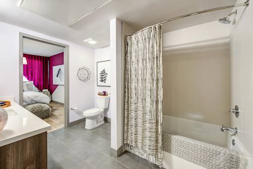 A bathroom with a white tub and a shower curtain.
