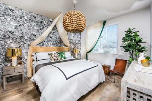 A bedroom with a canopy bed and a chair.