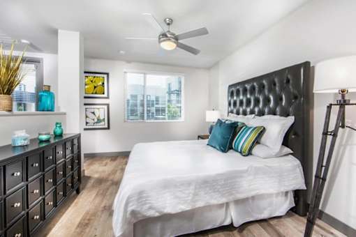A bedroom with a large bed and a black headboard.