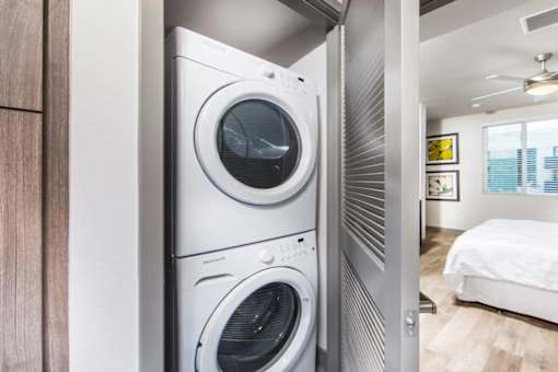 A modern laundry room with a washer and dryer stacked on top of each other.