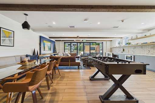 A modern kitchen with a long table and chairs.