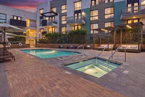 A modern building with a pool in the backyard.