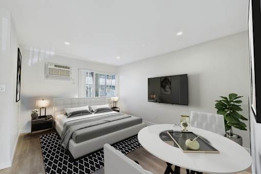 A modern bedroom with a large bed and a flat screen TV mounted on the wall.