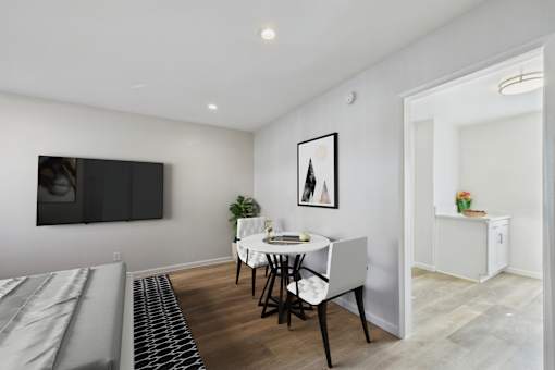 A dining room with a white table and chairs.