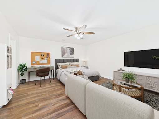 A bedroom with a bed, a desk, and a couch.