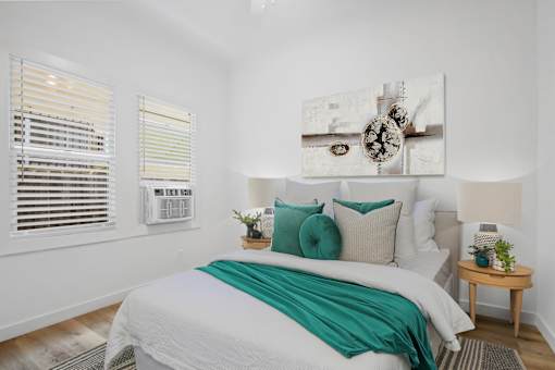 A bedroom with a large bed and a painting above it.