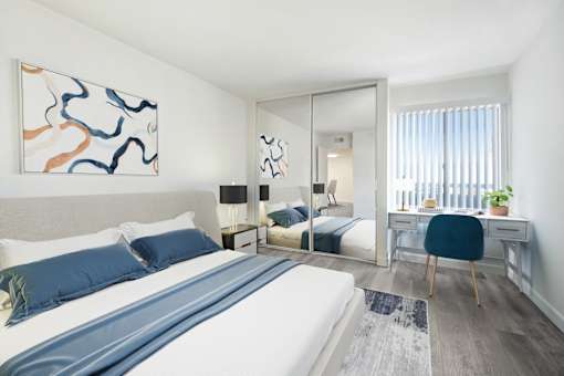A bedroom with a large bed and a painting on the wall.