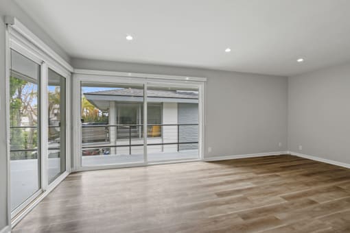A room with a sliding glass door leading to a balcony.