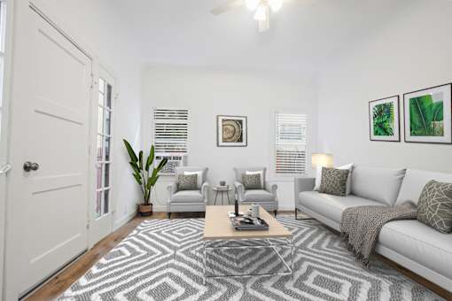A living room with a grey couch, a coffee table, and a rug with a geometric pattern.