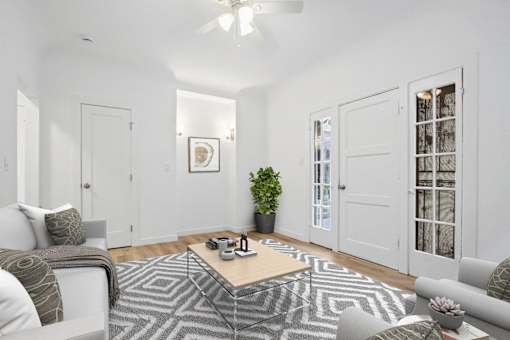 A living room with a patterned rug and a coffee table.