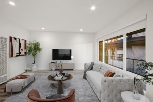 a living room with a white couch and a television