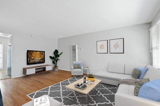 a living room with white furniture and a tv