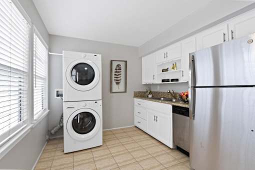 a washer and dryer in a kitchen with a sink and refrigerator