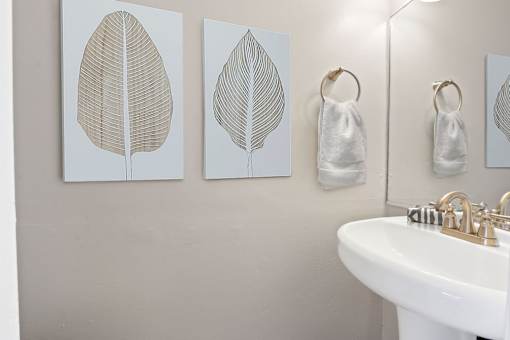 a bathroom with three paintings on the wall and a sink