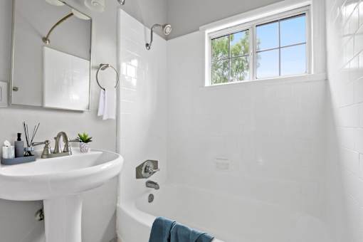 a bathroom with a sink and a tub and a window
