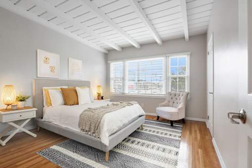 a bedroom with a bed and a chair and a window