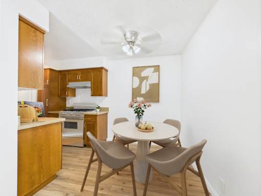 A kitchen with a table and chairs.
