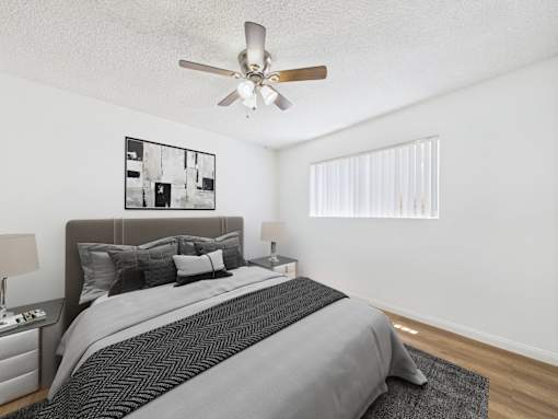 A bedroom with a large bed and a ceiling fan.