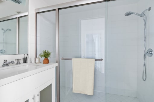 a white bathroom with a shower and a sink