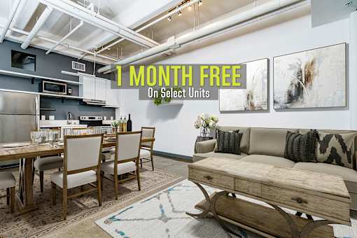 A modern kitchen and dining area with a sign offering 1 month free on select units.