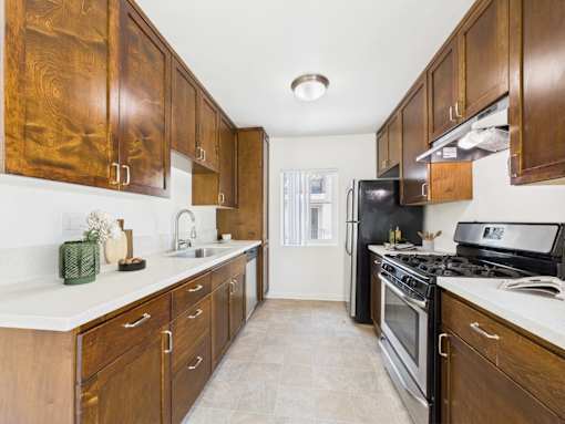 A kitchen with wooden cabinets and a black refrigerator.