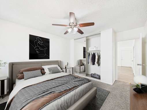 A bedroom with a large bed and a ceiling fan.