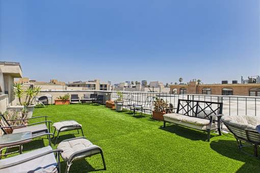 A patio with lawn chairs and a table.