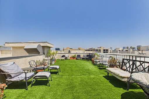 A patio with a lawn and chairs.