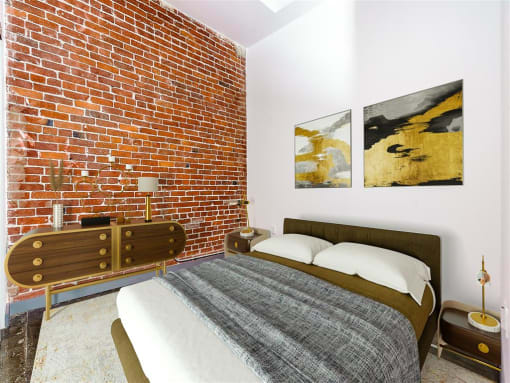 a bedroom with a bed and a dresser in front of a brick wall